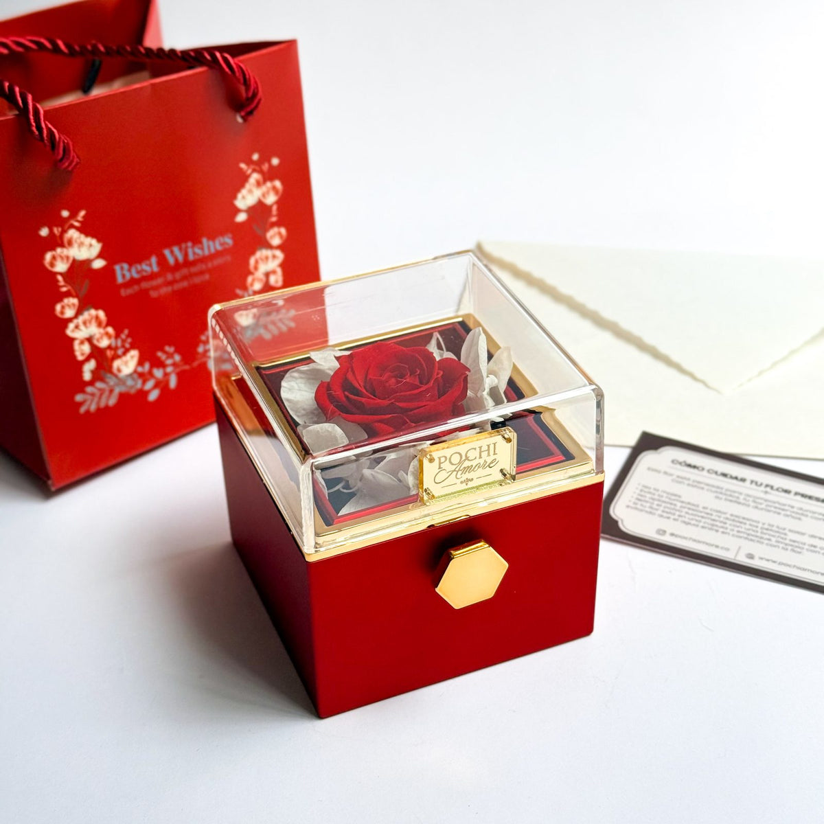 Joyero Giratorio Rosa Eterna rojo sobre la mesa junto a bolsa de regalo