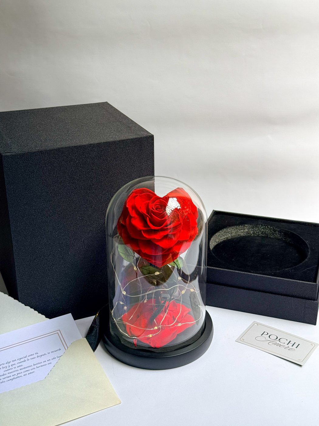 Rosa Eterna Corazón roja en cúpula de vidrio junto a caja de regalo